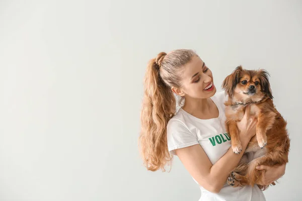 Junge Helferin mit Hund auf hellem Hintergrund — Stockfoto