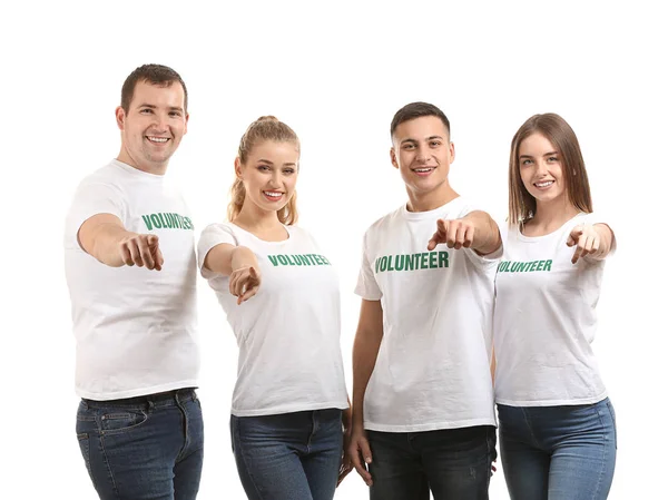 Equipe de jovens voluntários apontando para o espectador em fundo branco — Fotografia de Stock