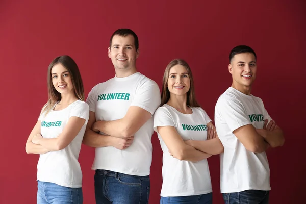 Equipe de jovens voluntários em fundo de cor — Fotografia de Stock