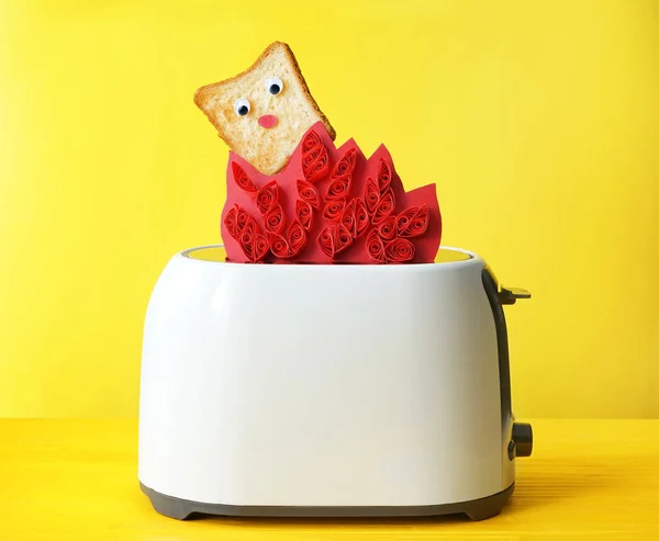 Composição engraçada com fatia de pão e torradeira no fundo de cor — Fotografia de Stock
