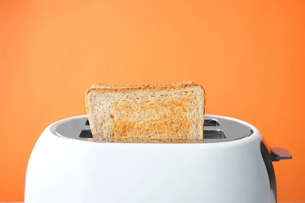 Fatias de pão com torradeira no fundo de cor — Fotografia de Stock