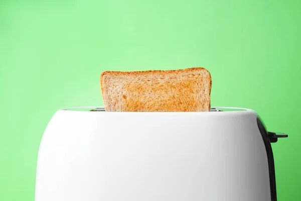 Slice of bread with toaster on color background — Stock Photo, Image