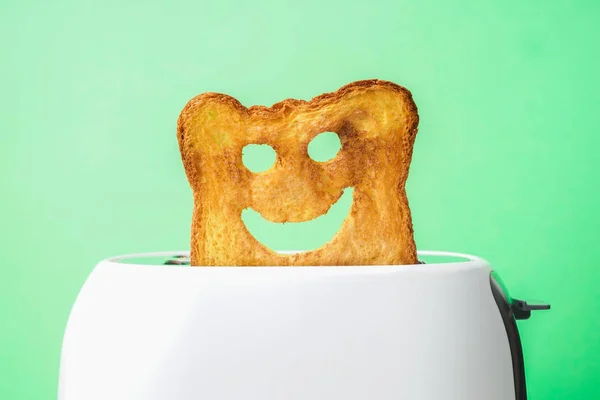 Funny slice of bread with toaster on color background — Stock Photo, Image