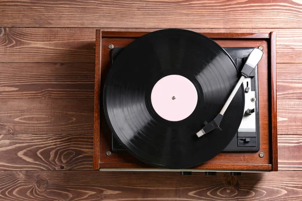 Record player with vinyl disc on wooden table — Stock Photo, Image