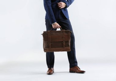 Şık genç adam resmi giyim ve çanta ışık arka plan üzerinde