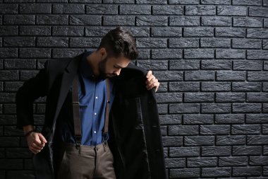 Şık genç adam karanlık duvara karşı