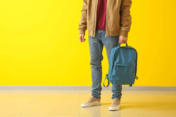 Elegantní mladý muž s batohem barevné zdi — Stock fotografie
