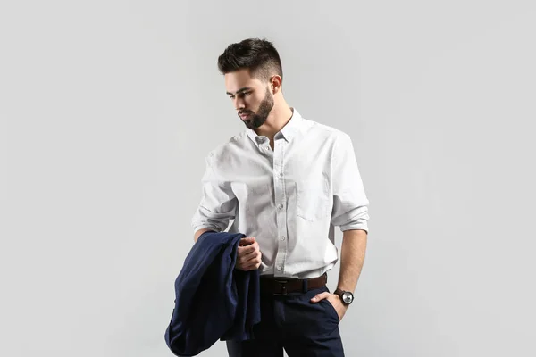 Fashionabla ung man i formella kläder på ljus bakgrund — Stockfoto