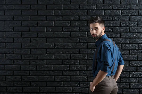 El joven a la moda contra la pared de ladrillo oscuro —  Fotos de Stock