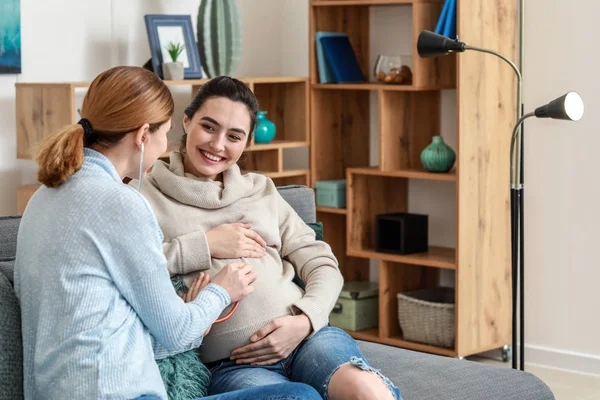 Дула с беременной женщиной дома — стоковое фото