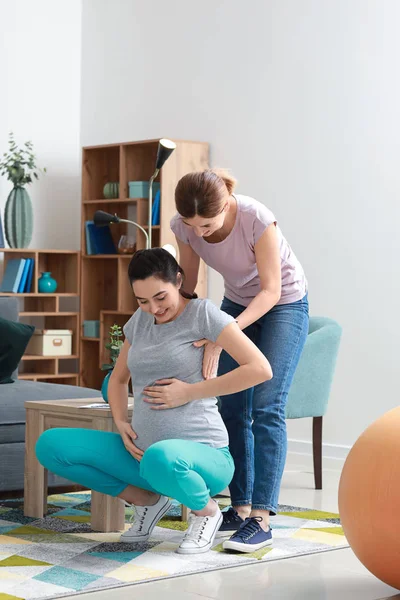 Doula e mulher grávida fazendo exercícios em casa — Fotografia de Stock