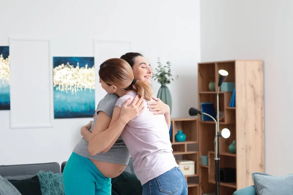 Mulher grávida feliz com doula em casa — Fotografia de Stock