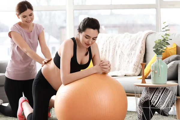 Doula massiert schwangere Frau zu Hause — Stockfoto