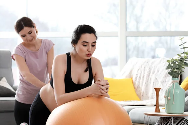 Doula massaging pregnant woman at home — Stock Photo, Image