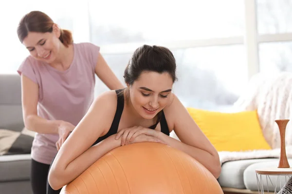 Doula masserer gravid kvinde hjemme - Stock-foto
