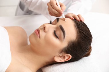 Güzellik salonunda kaş düzeltme ameliyatı olan genç bir kadın.