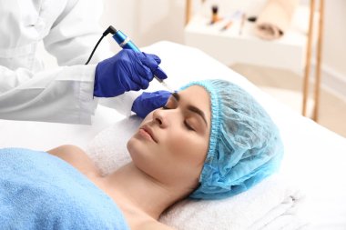 Güzellik salonunda kaş makyajı yapılan genç bir kadın.