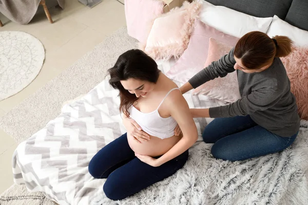 Doula massaging pregnant woman at home — Stock Photo, Image