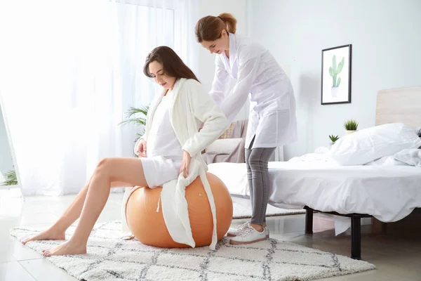 Doula massageando mulher grávida em casa — Fotografia de Stock