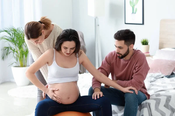 Casal grávida com doula em casa — Fotografia de Stock