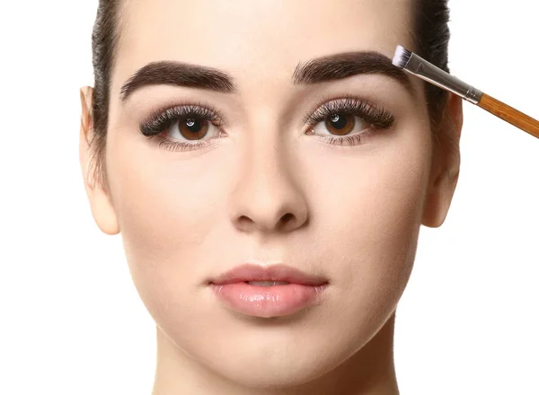 Mujer joven sometida a procedimiento de corrección de cejas sobre fondo blanco —  Fotos de Stock
