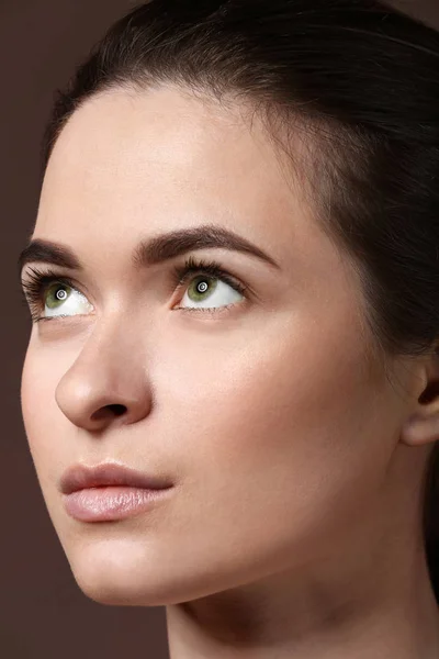 Young woman with beautiful eyebrows on color background, closeup — Stock Photo, Image