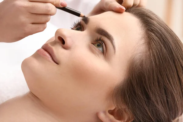 Jonge vrouw ondergaan wenkbrauw correctie procedure in schoonheidssalon — Stockfoto