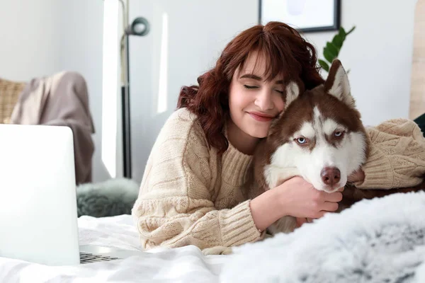 Evde yatakta yatarken onun sevimli köpek olan kadın — Stok fotoğraf