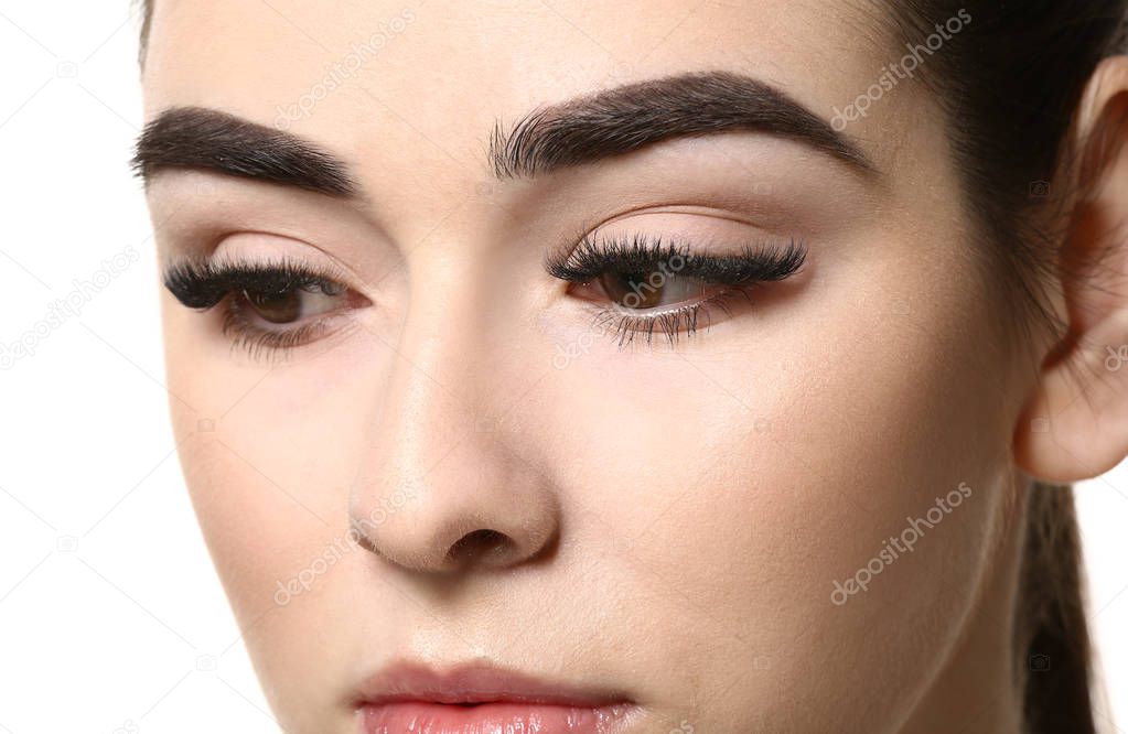 Young woman with beautiful eyebrows on white background, closeup