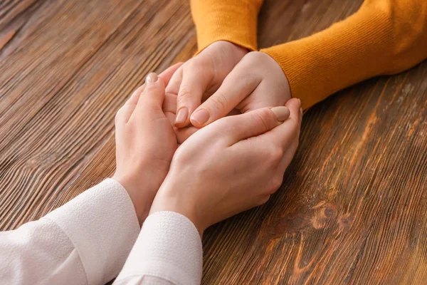 Manos de mujer consolando a su amigo sobre fondo de madera —  Fotos de Stock