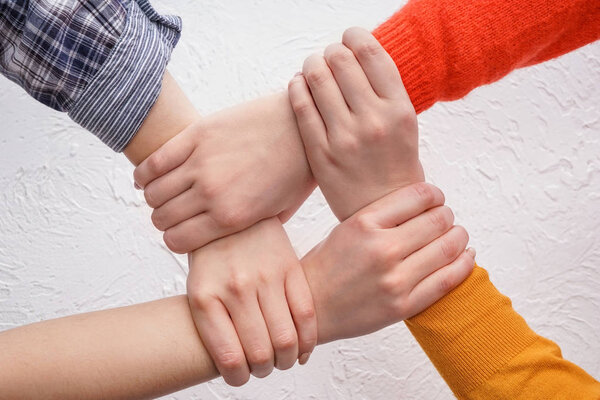 People putting hands together on light background