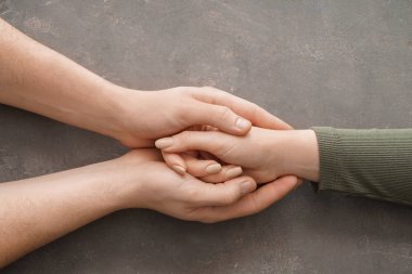 Genç kadın gri arka plan üzerinde rahatlatıcı adamın elleri