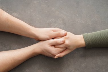 Genç kadın gri arka plan üzerinde rahatlatıcı adamın elleri