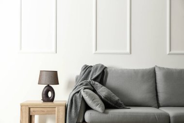 Modern kanepe ve lamba beyaz duvarının yakınında olan tablo