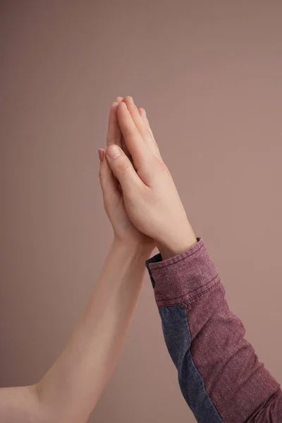 Young man and woman touching palms against color background — Stock Photo, Image