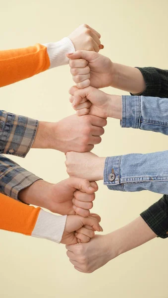 Група людей тримає руки разом на світлому тлі. Концепція єдності — стокове фото