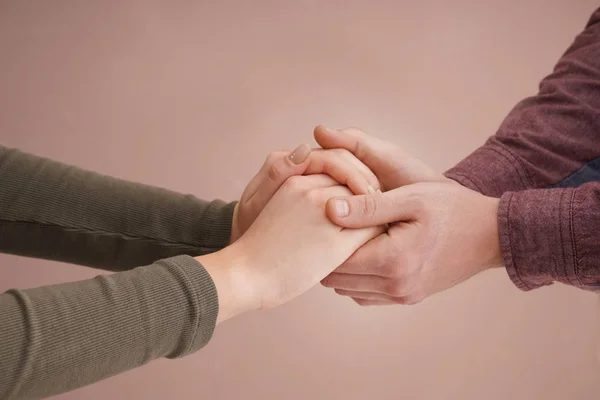 Young couple holding hands together on color background — Stock Photo, Image