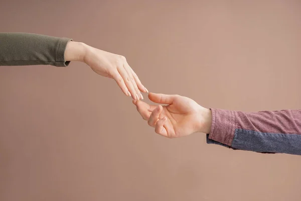 Man and woman giving each other hands on color background. Concept of support and help — Stock Photo, Image