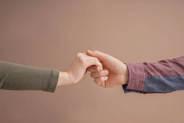 Pareja joven cogida de la mano sobre fondo de color — Foto de Stock