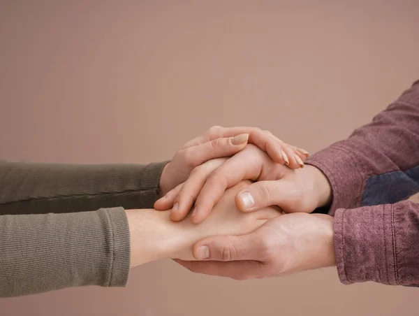 Молода пара тримає руки разом на кольоровому фоні — стокове фото