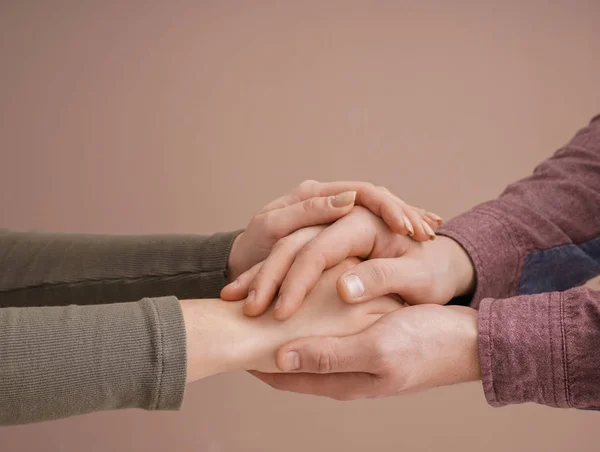 Giovane coppia che tiene le mani insieme su sfondo di colore — Foto Stock