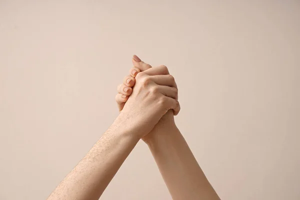 Women holding hands on light background — Stock Photo, Image