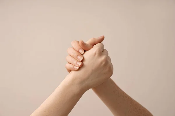 Women holding hands on light background — Stock Photo, Image