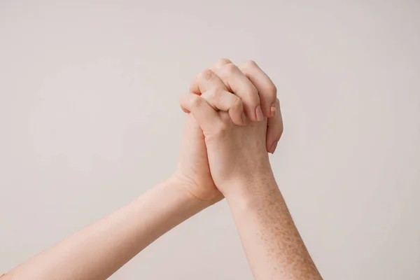 Mujeres jóvenes cogidas de la mano contra fondo claro — Foto de Stock