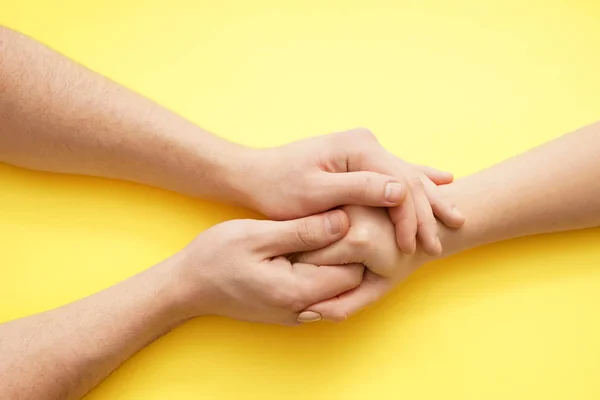 Hombre cogido de la mano de mujer joven sobre fondo de color —  Fotos de Stock