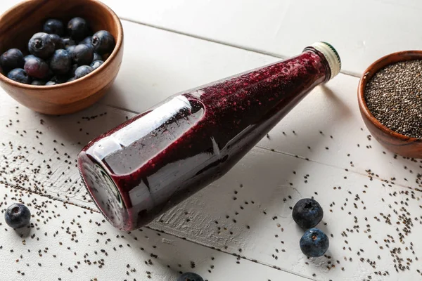 Bottle of blueberry juice and chia seeds on white wooden table — Stock Photo, Image