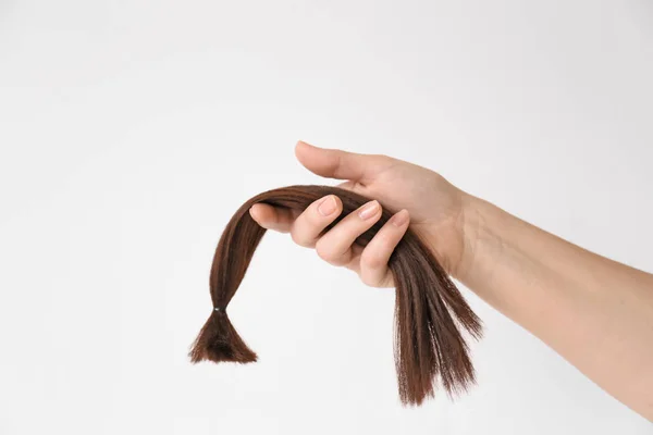 Női kéz a hajfürtöt a világos háttér. Az adományozás fogalma — Stock Fotó