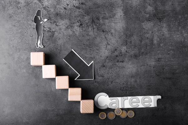 Composition with paper human figure, career ladder and arrow directed downwards on grey background. Concept of career failure — Stock Photo, Image