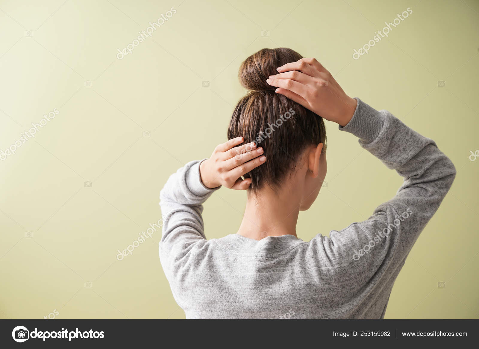 Young woman with hair bun on color background Stock Photo by ©serezniy  253159082
