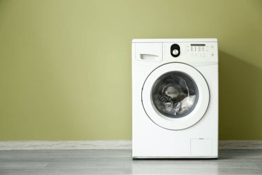 Renk duvarının yakınında modern çamaşır makinesi